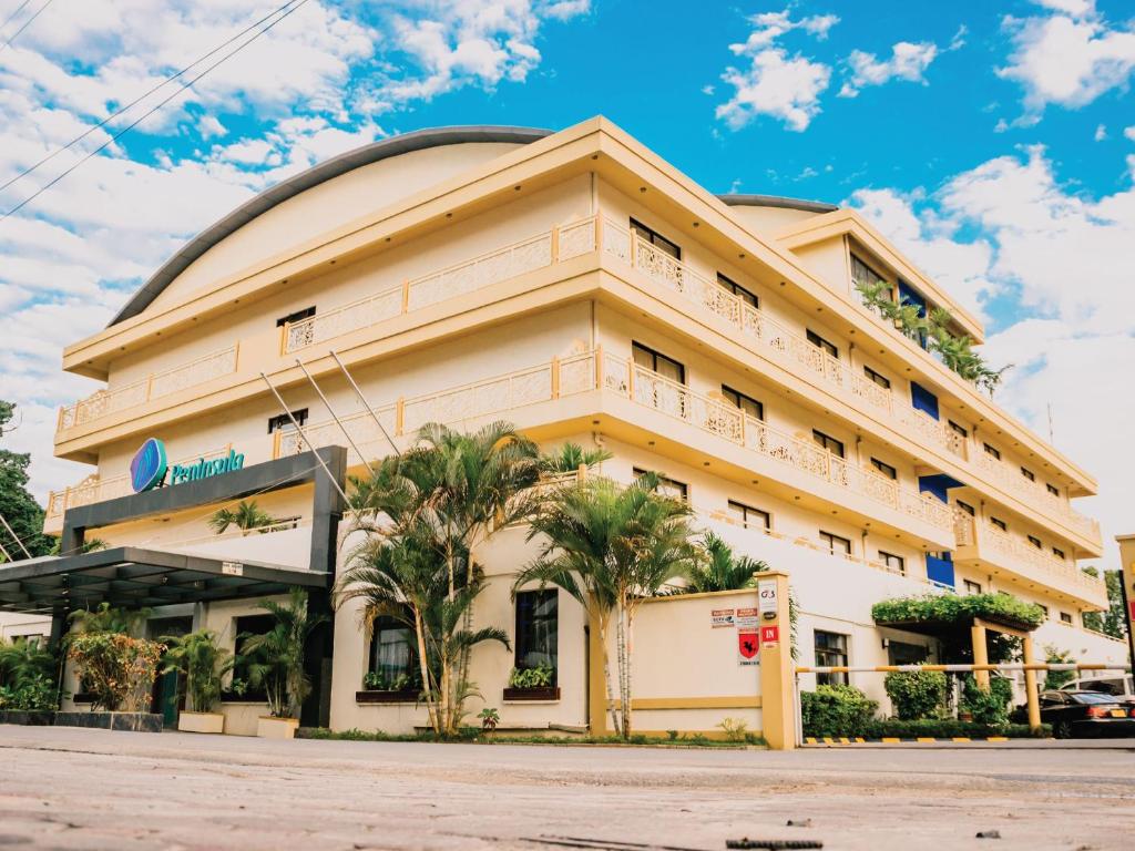 达累斯萨拉姆Peninsula Hotel Dar Es Salaam的一座棕榈树建筑