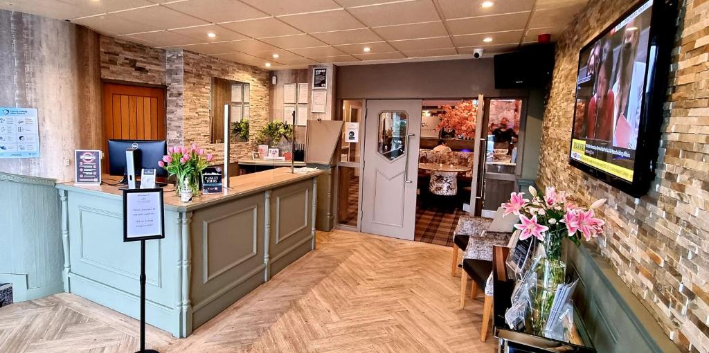 a restaurant with a counter and a bar in a room at Mill and Brae in Paisley