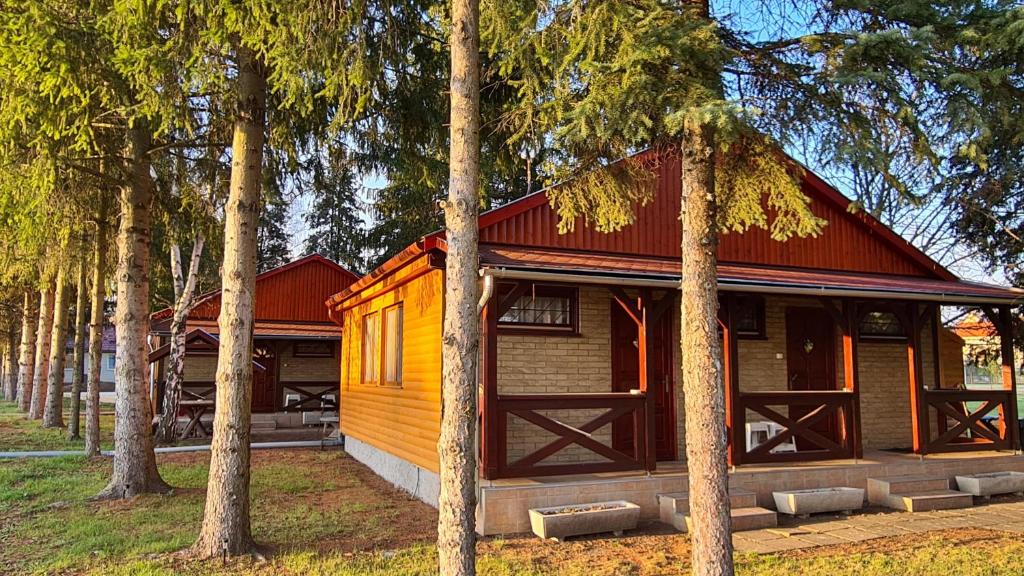 a cabin in the middle of a forest with trees at Strand Apartmanok in Bogács