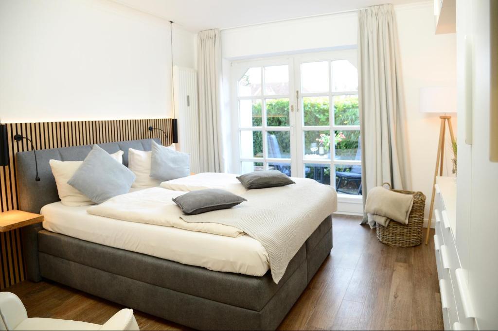 a bedroom with a large bed with pillows on it at Am Rosenhain 14 Am Rosenhain 14 Appartement 3 in Timmendorfer Strand