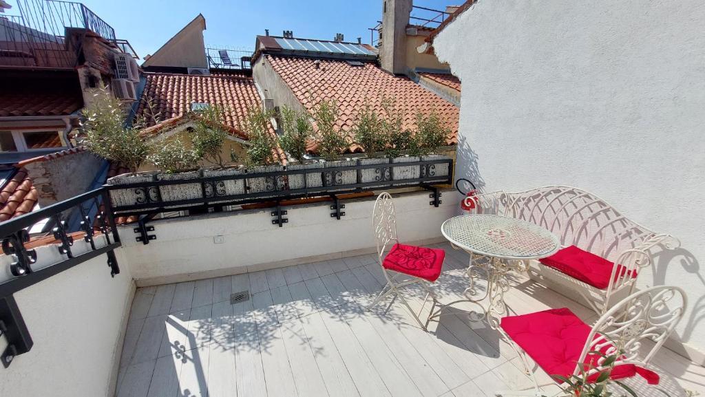 un patio con 2 sillas y una mesa en el balcón en Piranum Guesthouse with terrace, en Piran