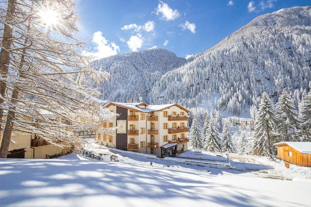 un hôtel dans les montagnes dans la neige dans l'établissement Residence Hotel Santa Maria piscina e wellness, à Peio Fonti