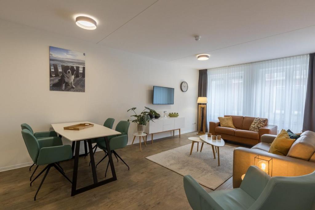 ein Wohnzimmer mit einer Couch und einem Tisch und Stühlen in der Unterkunft Luxury 4 person apartment pet allowed Zoutelande in Zoutelande