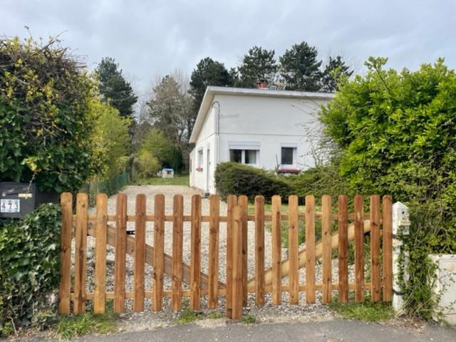 une clôture en bois devant une maison dans l'établissement Sanvent, à Fort-Mahon-Plage