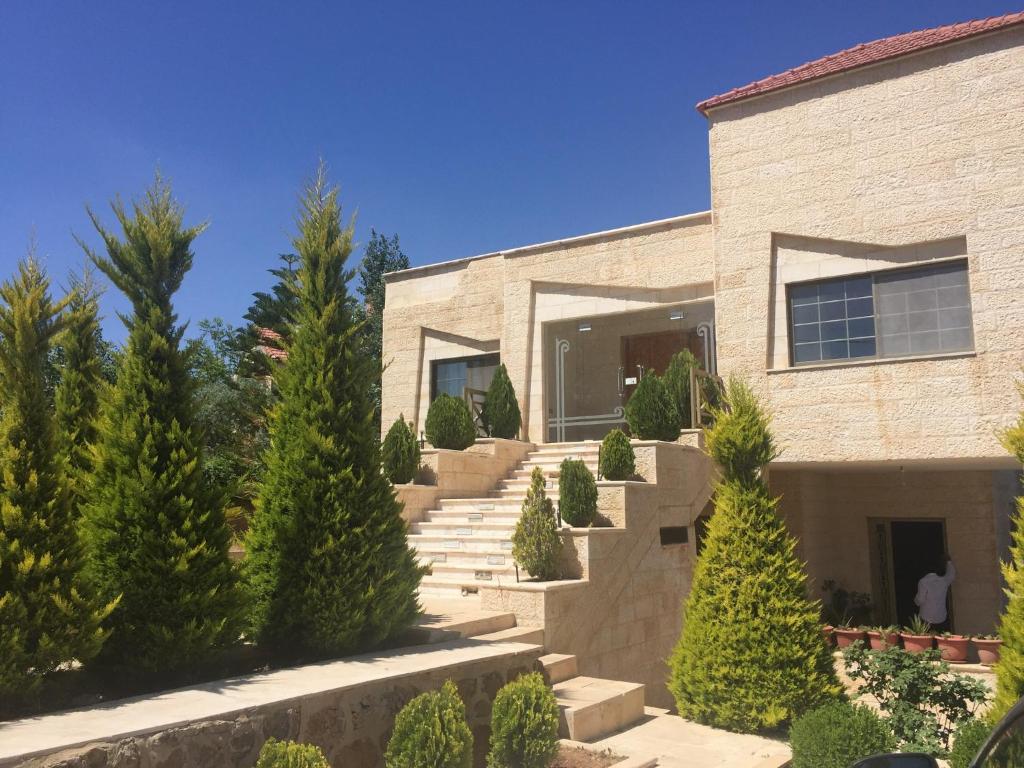 a brick building with stairs and trees in front of it at 4 bedrooms house with city view balcony and wifi at Amman in Amman