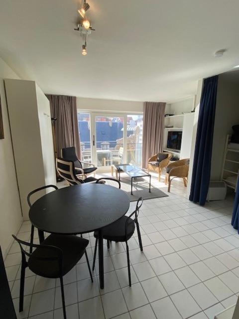a room with a table and chairs and a living room at Cape Cod 402 in Nieuwpoort