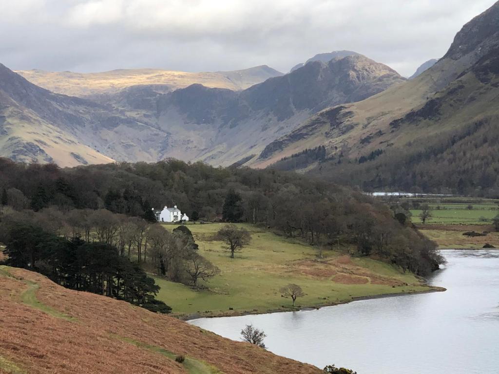 a view of a river with mountains in the background at Wood House in Cockermouth