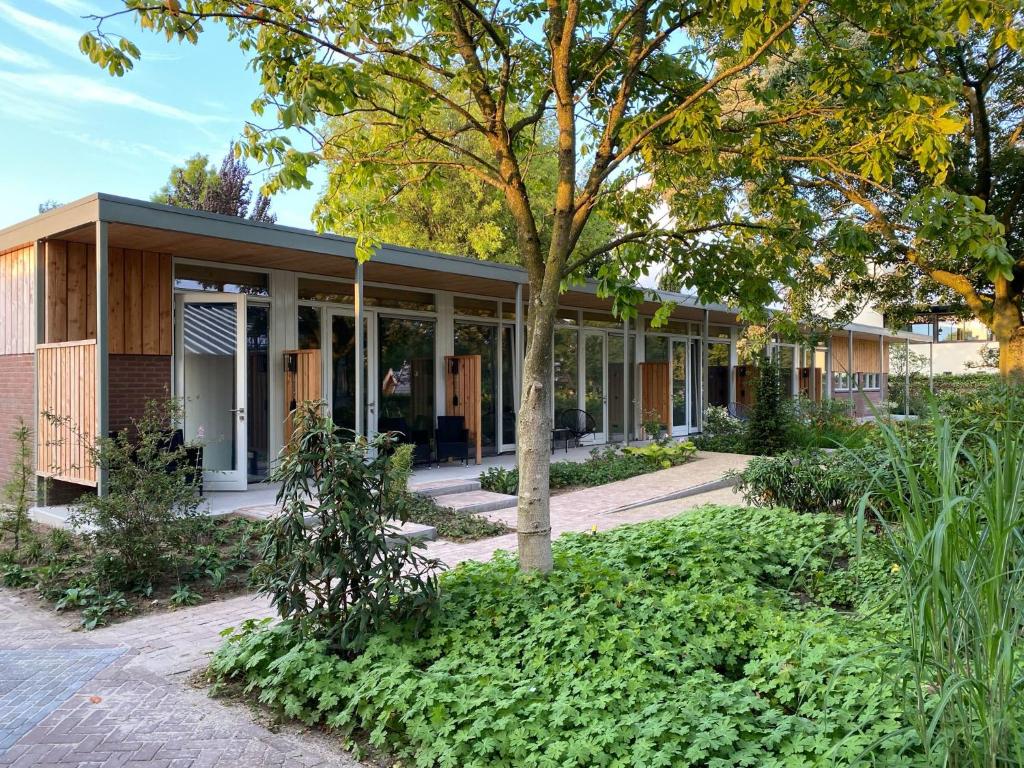 a building with a tree in front of it at Achterhoeks Goed, Bed & Breakfast in Vragender in Vragender