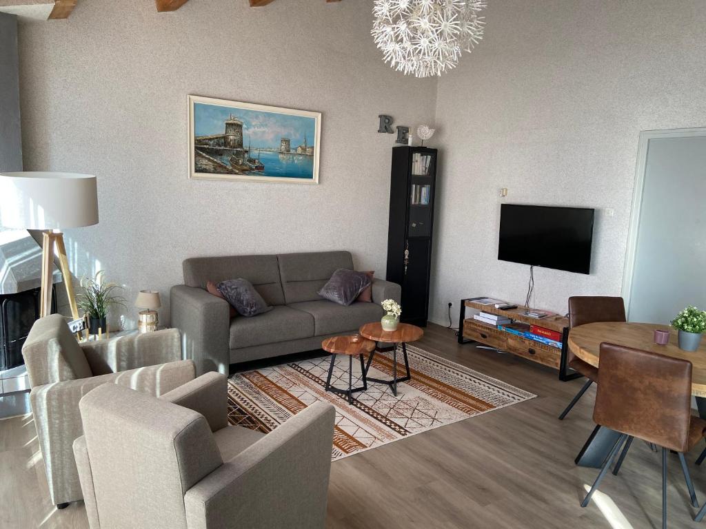 a living room with a couch and a tv at Beach house Atlantique 400m de la plage in Le Bois-Plage-en-Ré