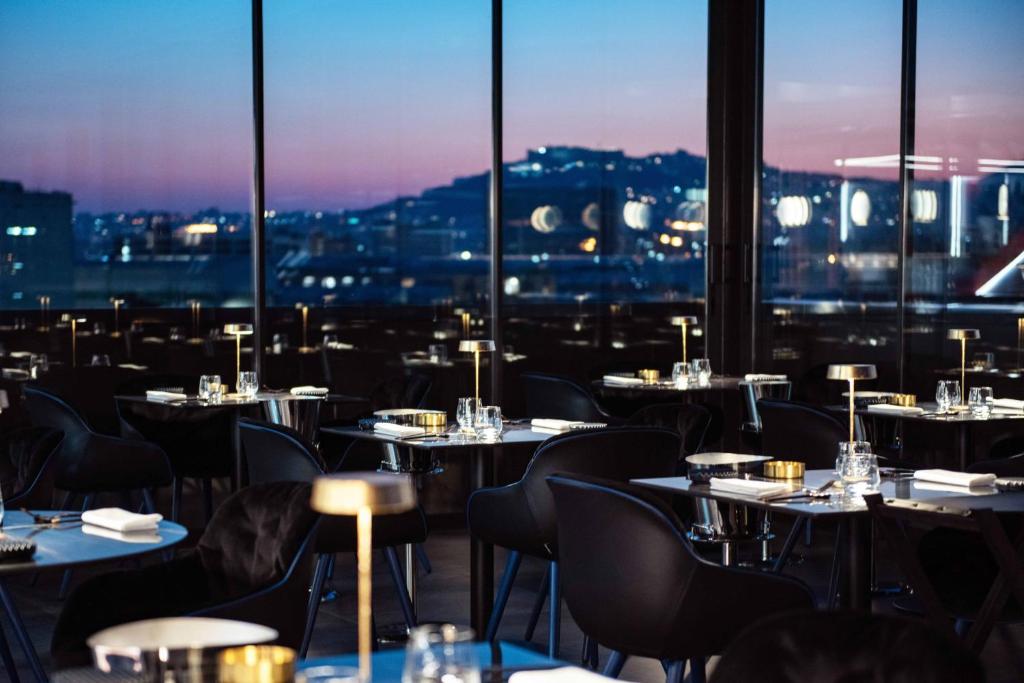 a restaurant with tables and chairs and a view of the city at Gold Tower Lifestyle Hotel in Naples