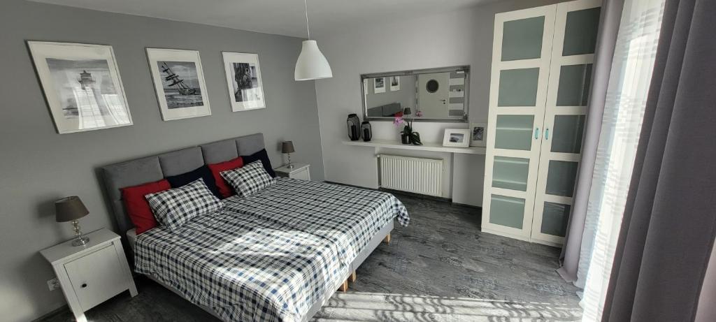 a bedroom with a bed with a checkered bedspread at Apartamenty Aquarius - Formoza in Gdynia