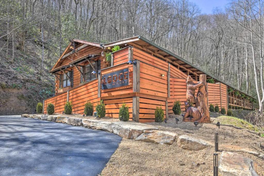 uma grande cabana de madeira com uma estrada em frente em The Lodge Nantahala River em Bryson City