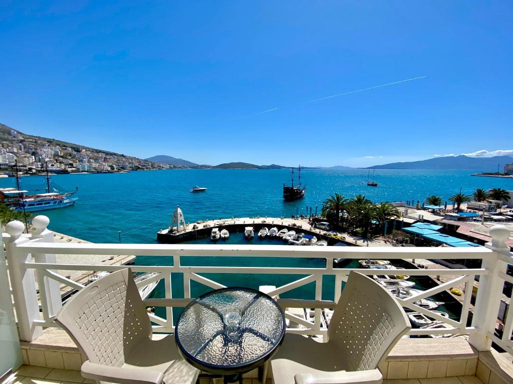 a balcony with chairs and a view of the water at Sun N Blue Hotel in Sarandë