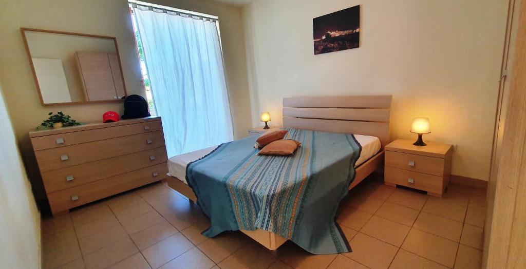 a bedroom with a bed and a dresser and a mirror at Via Ugento Apartments - GiHome in Sant'Isidoro