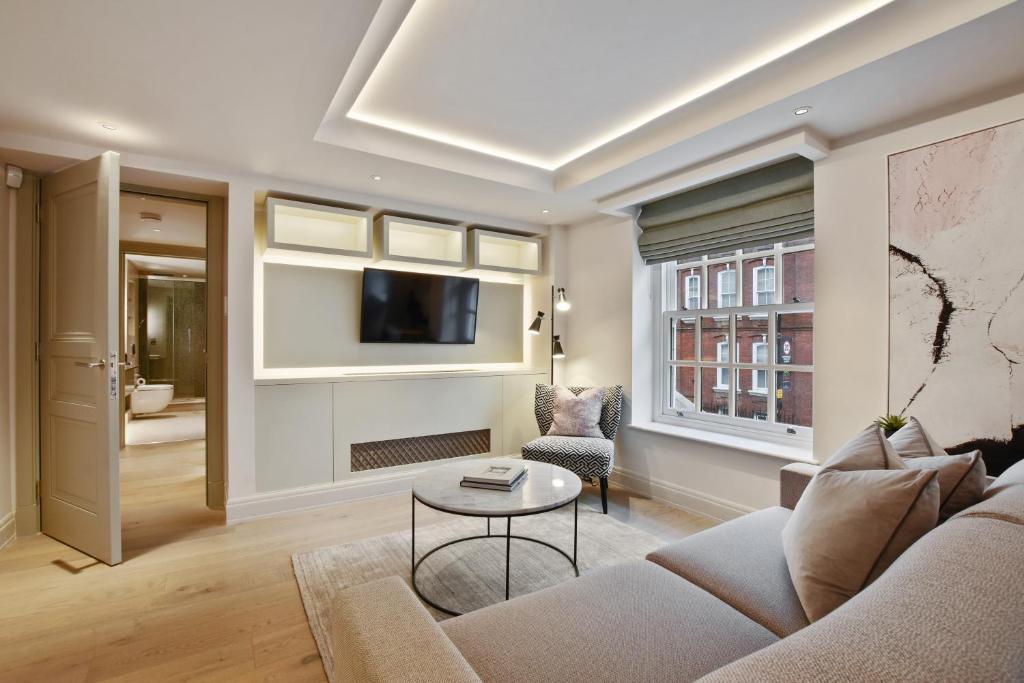 a living room with a couch and a tv at Hope House Residences by Q Apartments in London