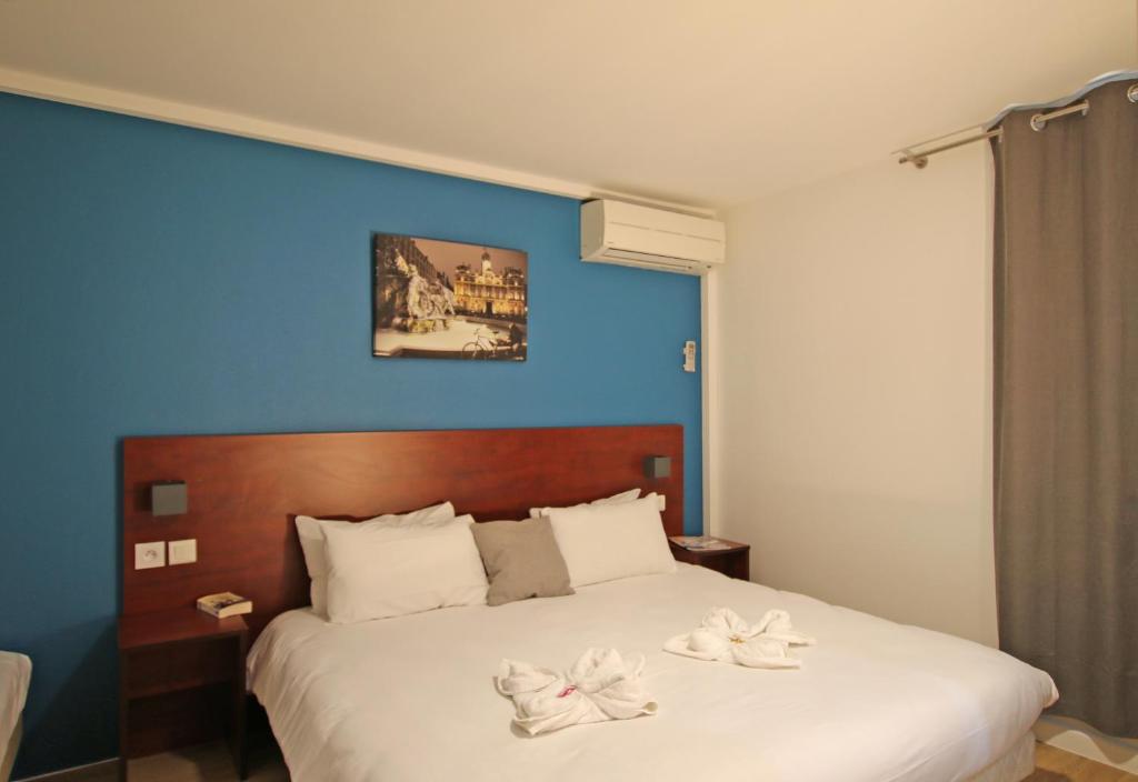 - une chambre avec un lit et des serviettes dans l'établissement Initial by Balladins Lyon Villefranche-sur-Saône, à Villefranche-sur-Saône