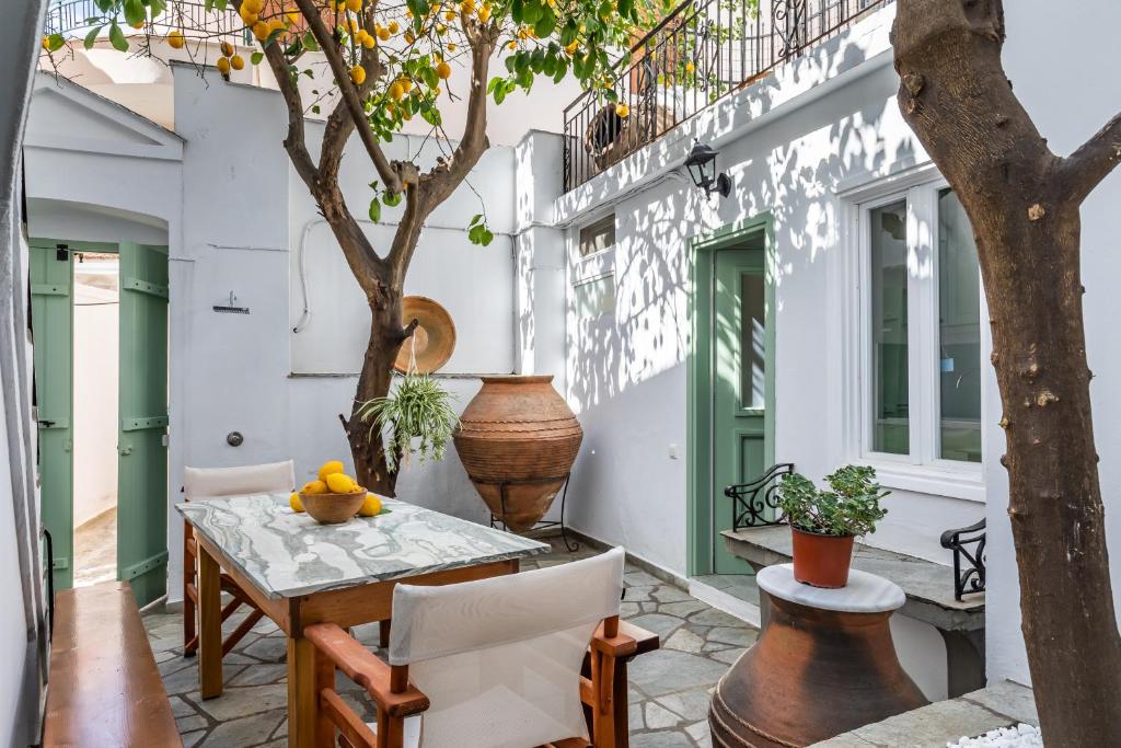 d'une terrasse avec une table, des chaises et un arbre. dans l'établissement Lemon Garden House Skopelos, à Skopelos