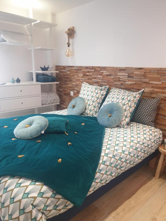 ein Schlafzimmer mit einem Bett mit blauen Kissen darauf in der Unterkunft Maisonnette individuelle pour 4 personnes 2 chambres Terrasse - Design & Haute Qualité in Bourbourg