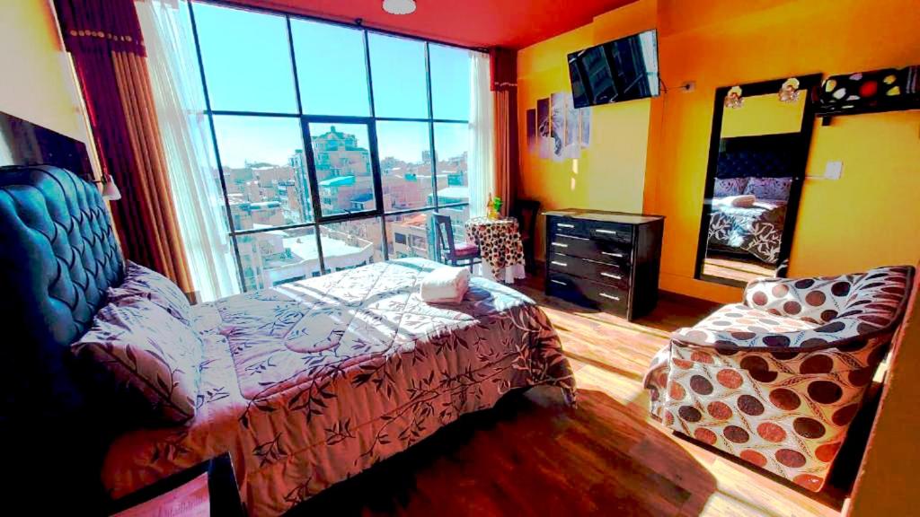een slaapkamer met een bed en een groot raam bij Hotel Paraíso in Callampaya