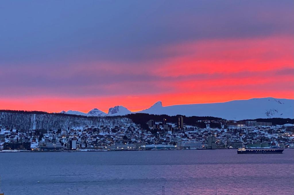 a view of a city at sunset with mountains at Polar Arctic View - Free Parking! in Tromsø