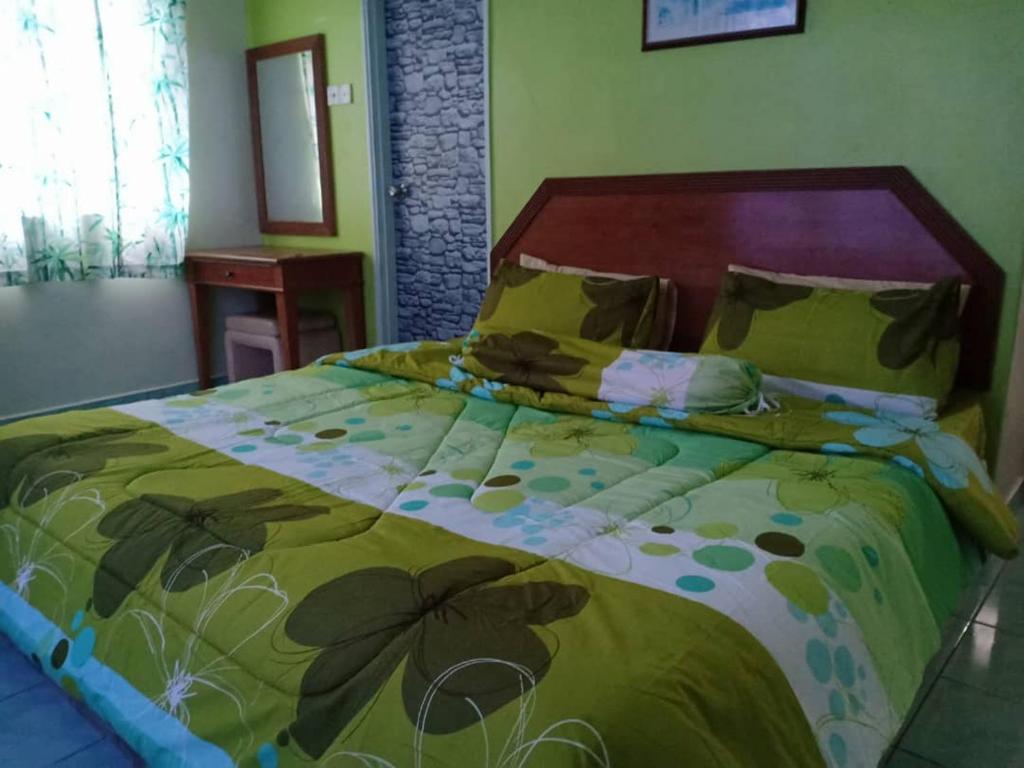 - une chambre avec un grand lit et une couette verte dans l'établissement JC Sunshine Bay Resort Apartment Port Dickson, à Port Dickson