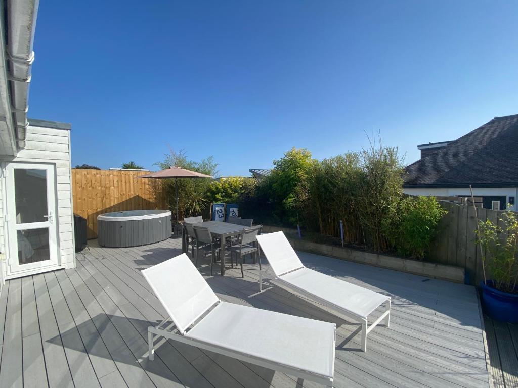 a patio with two white chairs and a table at The Bolthole in Kingsbridge