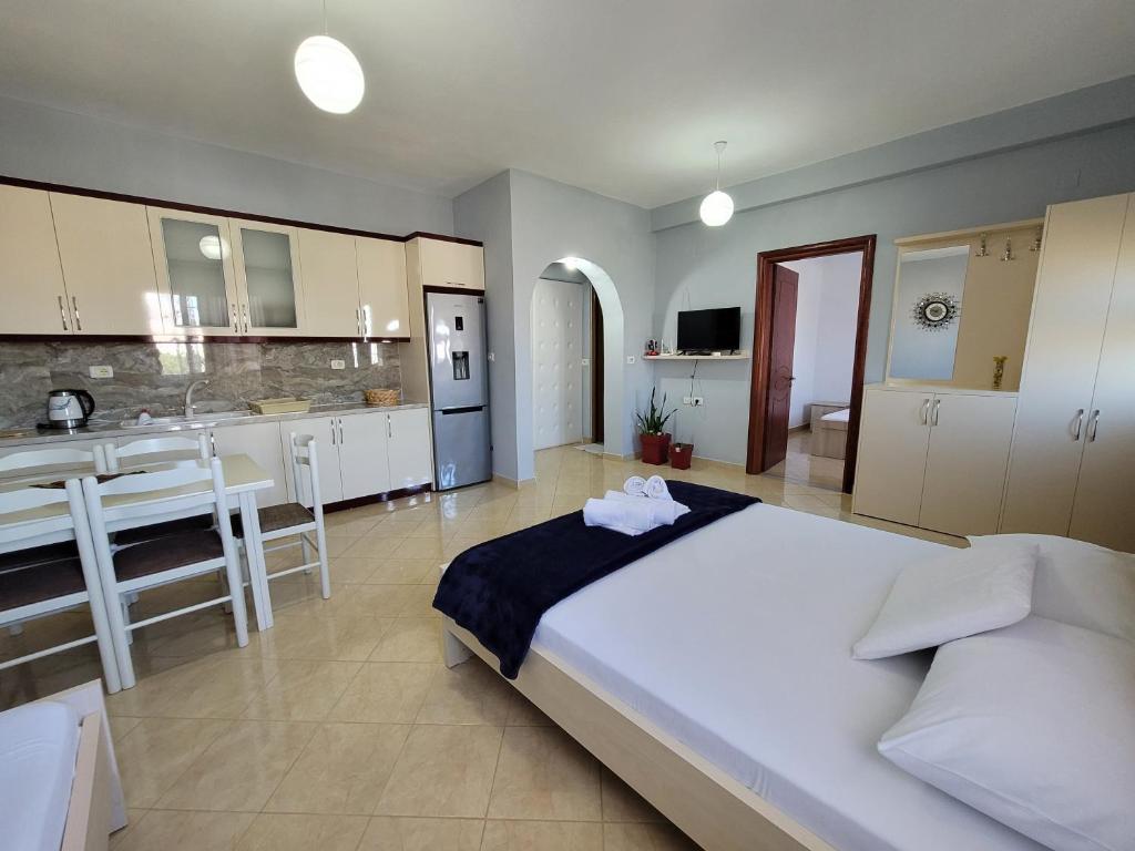 a bedroom with a large bed and a kitchen at Guesthouse Redilka in Ksamil