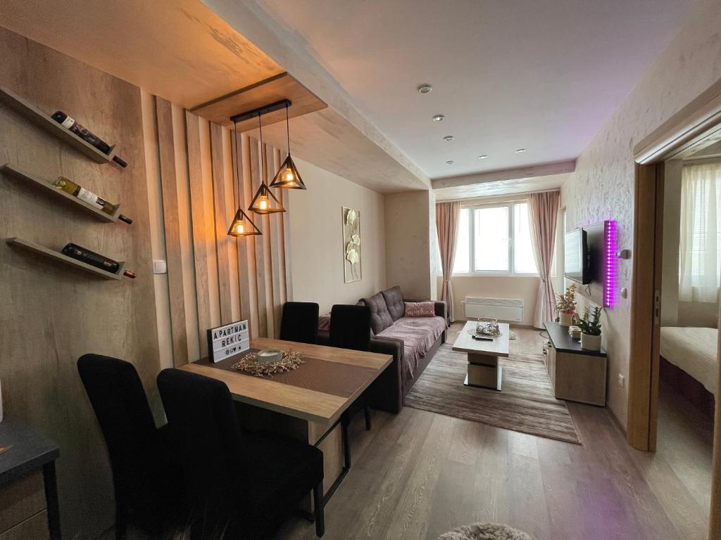 茲拉蒂博爾的住宿－Apartman Rekić 23 Gondola，客厅配有桌子和沙发