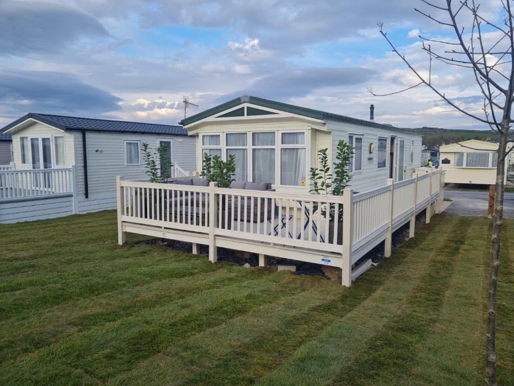 a manufactured home with a porch and a deck at Clwyd 6 in Borth