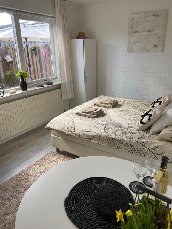 1 dormitorio con cama, mesa y ventana en Studioverhuur Vlissingen en Vlissingen