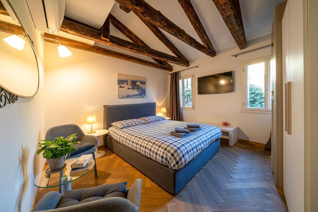 a bedroom with a bed and chairs in a room at Centrale appartamento per 4 persone in Venice