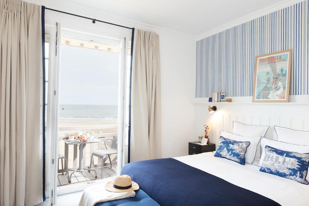 a bedroom with a bed and a view of the ocean at Le Flaubert in Trouville-sur-Mer