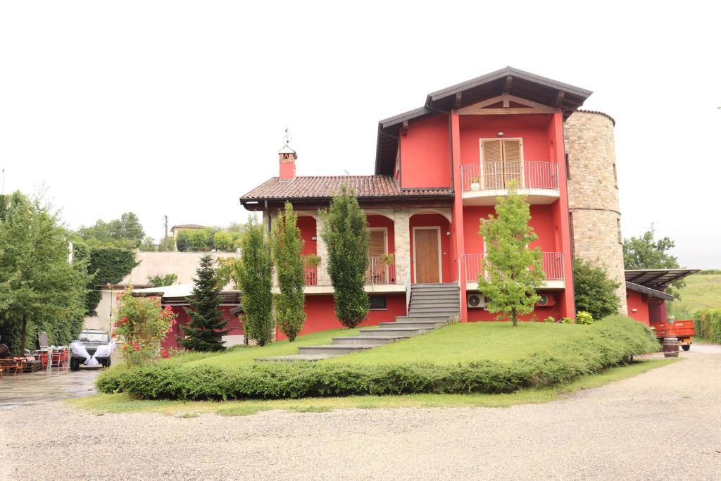 a red house with stairs in front of it at AGRITURISMO BOSCO LONGHINO in Santa Maria della Versa