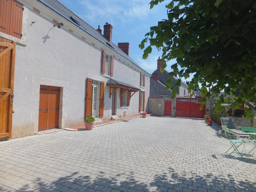 een lege binnenplaats van een wit gebouw met een patio bij Les 4 vents in Vineuil