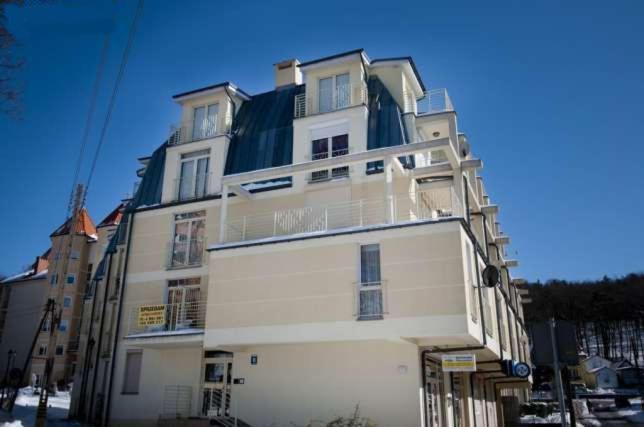 duży biały budynek z aleją w obiekcie Apartment Sophia auf der Insel Wollin w mieście Międzyzdroje
