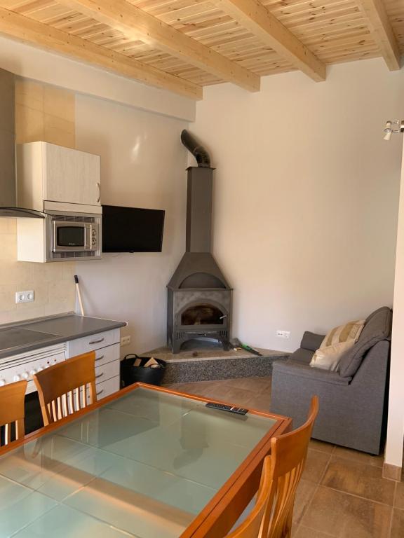 een keuken en een woonkamer met een tafel en een open haard bij Agradable casa con chimenea y patio totalmente privado in Barahona
