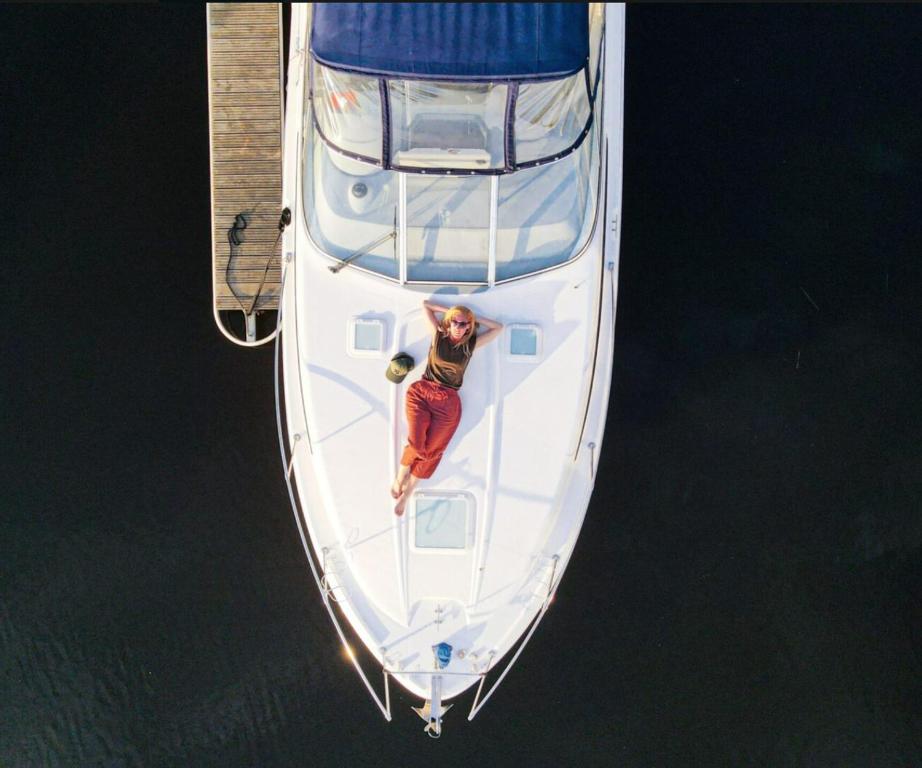 a woman is laying on a boat at a dock at Botel "California" in Dreverna