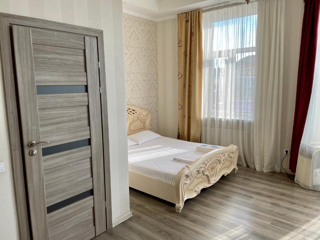 um pequeno quarto com uma cama e uma janela em Apartment Studio-біля Вокзалу-недалеко від Центру-Городоцька 151 em Lviv
