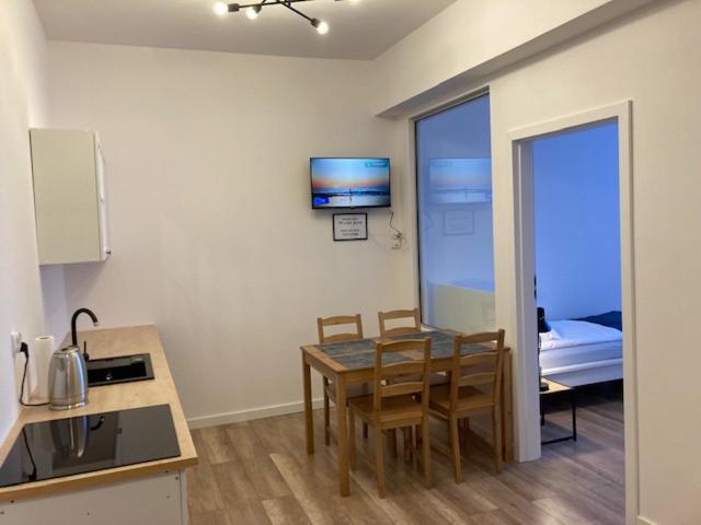 a kitchen with a table and chairs in a room at Apartament Centrum Szczytno II in Szczytno