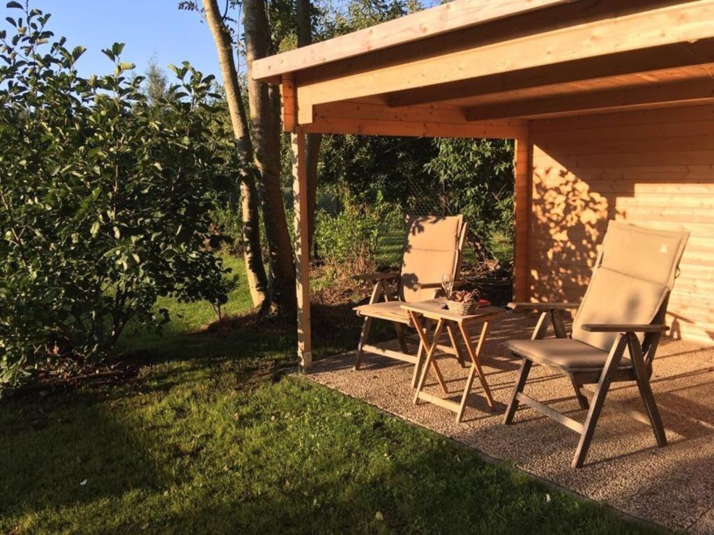 2 chaises et une table sous un pavillon dans l'établissement Holidayhouse - Lepelblad 7 Nieuwvliet-Bad, à Nieuwvliet