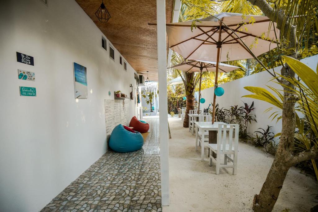 un patio con mesa y sombrilla en Mystic Maldives Mathiveri Retreat en Mathiveri