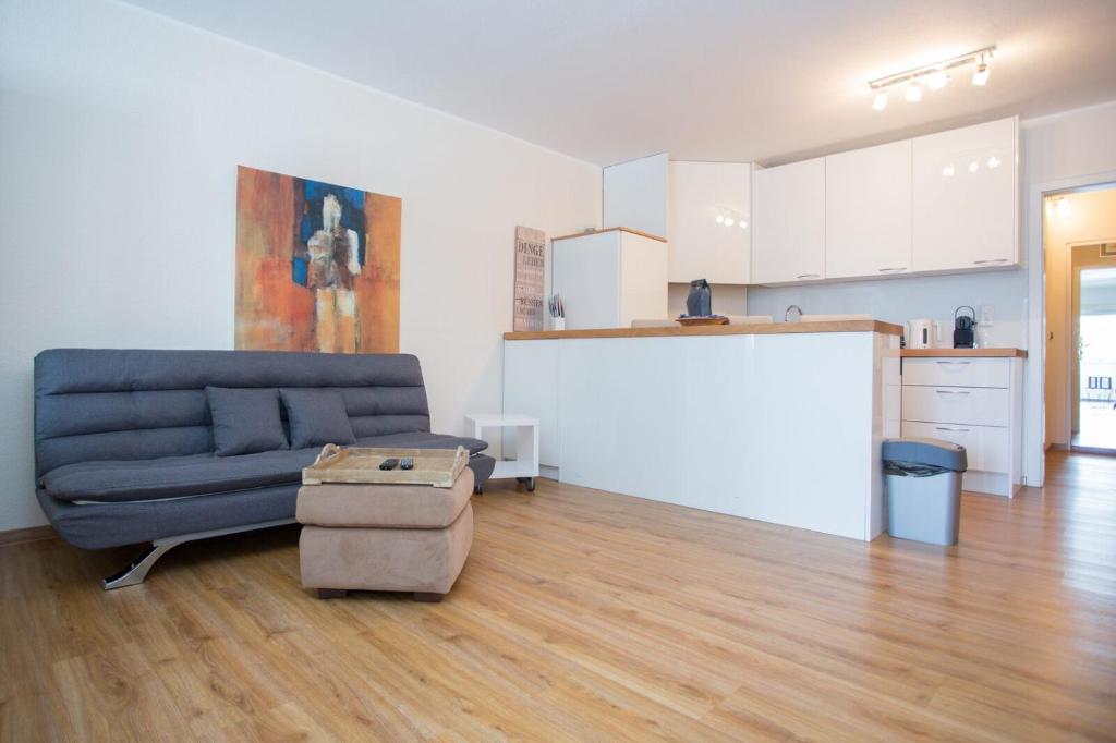uma sala de estar com um sofá azul e uma cozinha em Apartment - Feldstrasse 30-O Winterberg em Winterberg