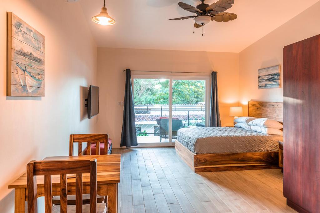 um quarto com uma cama, uma mesa e uma janela em Palm Beach Inn em Playa Grande
