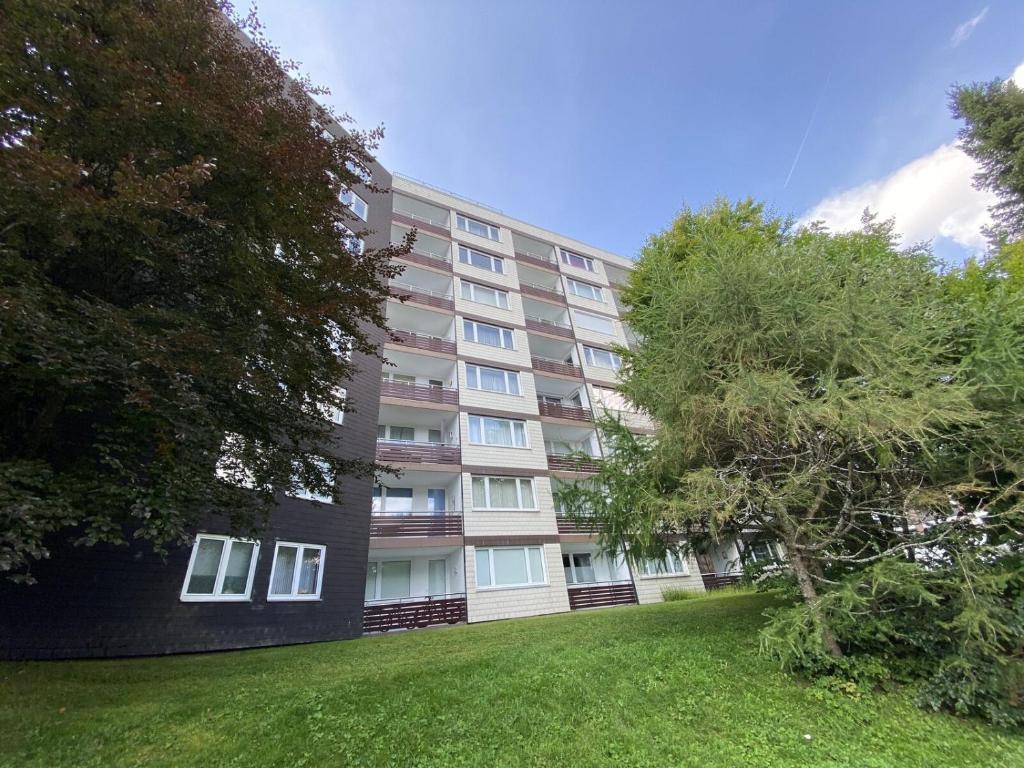 a large apartment building with a green lawn in front of it at Appartement - Weltringpark 2-T Winterberg in Winterberg