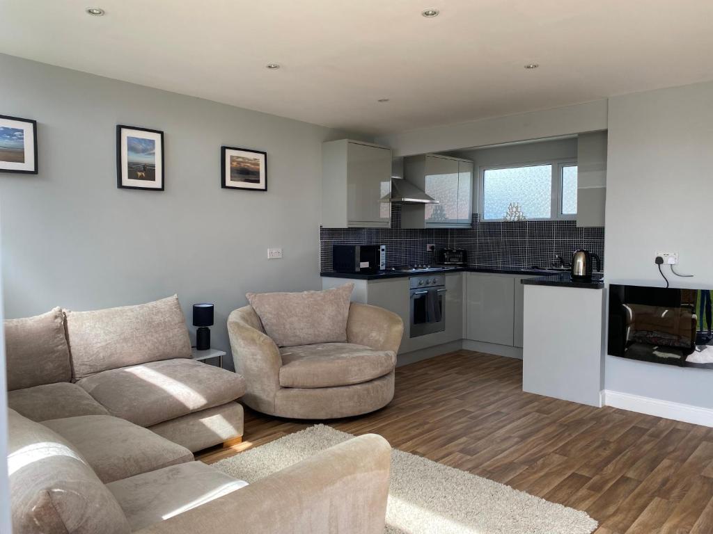 a living room with a couch and two chairs and a kitchen at Shore Thing Holiday Chalet Parkdean K81 in Camber