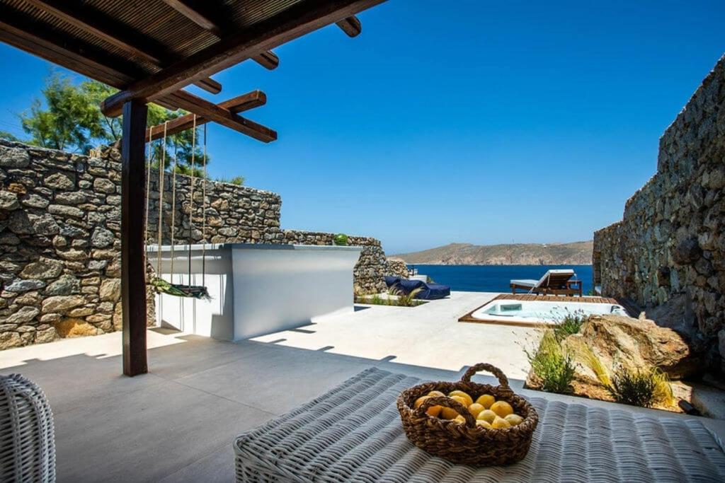 a basket of fruit sitting on a table on a patio at Villa ANASA private Pool & Jacuzzi 8pax at Panormos in Mykonos