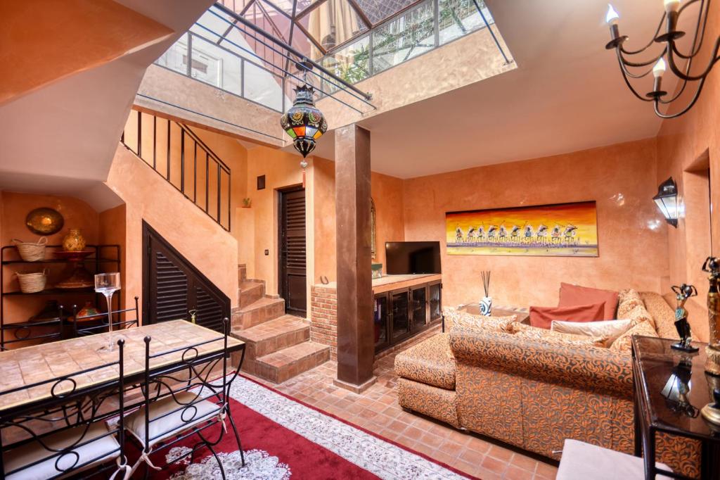 a living room with a couch and a fireplace at Riad Palmi magnifique Riad centre ville - 6px in Agadir
