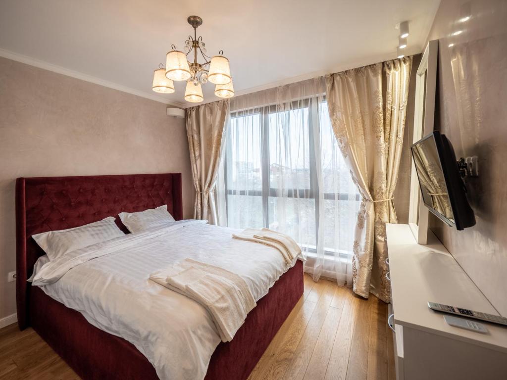 a bedroom with a large bed and a large window at The Boulevard Luxury Apartment in Sofia