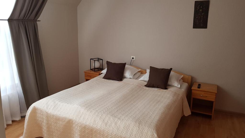 a bedroom with a white bed with two pillows at Hotel Melturi in Melturi