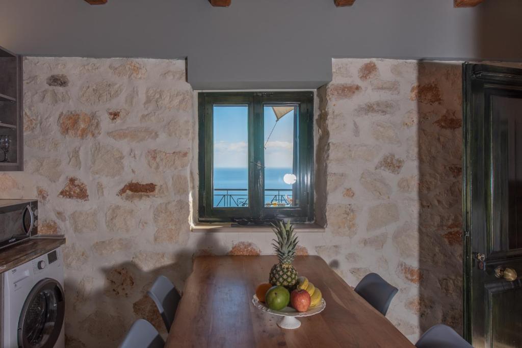 a kitchen with a table with a bowl of fruit on it at Xigia Escape villas in Khartáta